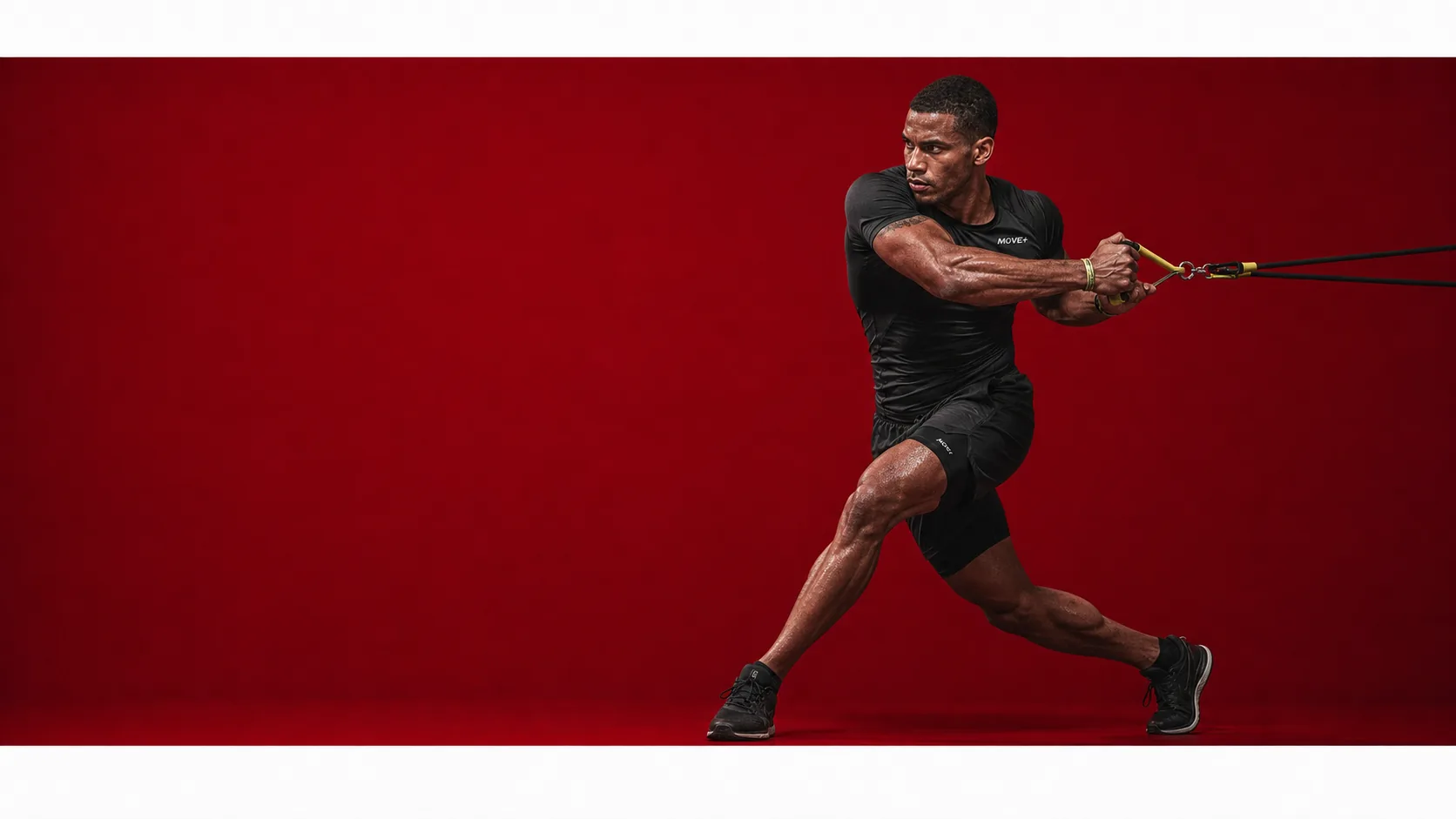 Athlete in black training apparel against a red studio background