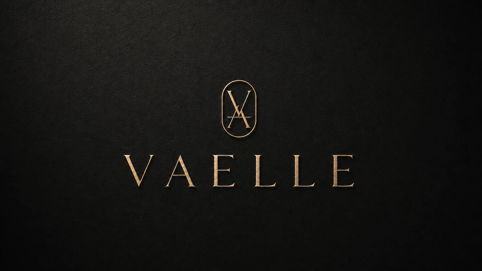 VAELLE gold wordmark and monogram on a black material surface